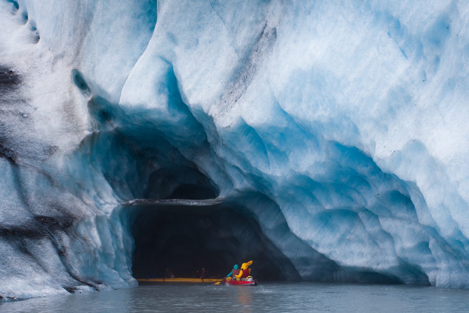 Kayak nella grotta di ghiaccio blu nell'iceberg del ghiacciaio, Alaska