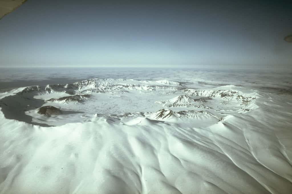 Veduta aerea a nord della caldera di Okmok, un cratere circolare di 9,3 km di diametro (5,8 miglia) che tronca la sommità di un grande vulcano a scudo nella parte nord-orientale dell'isola di Umnak nelle Isole Aleutine orientali.