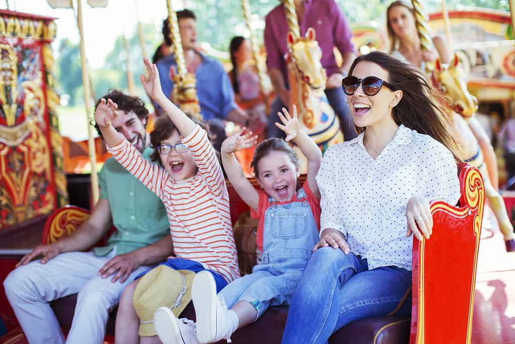 Famiglia sulla giostra nel parco divertimenti