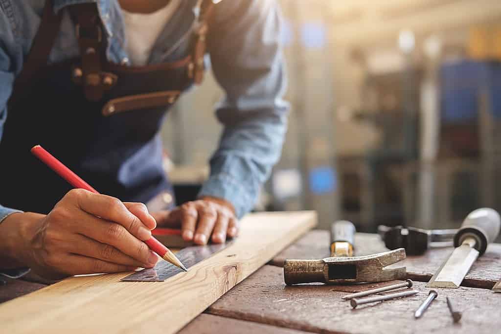 Falegname che lavora su macchine per la lavorazione del legno in falegnameria.  donna lavora in una falegnameria.