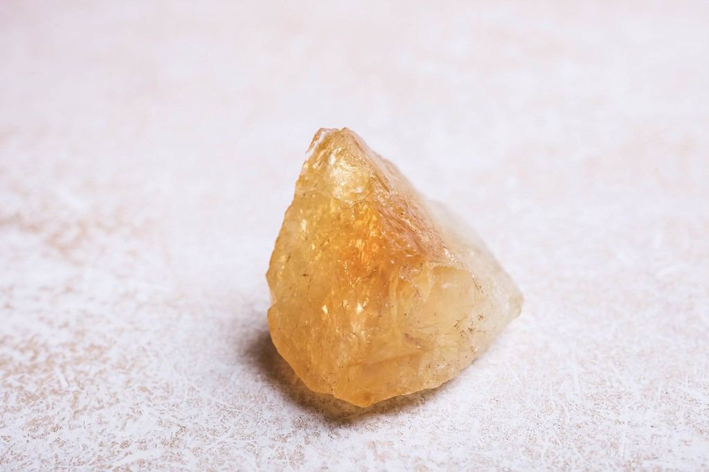 Pietra minerale citrino su sfondo bianco.  Il concetto di meditazione.
