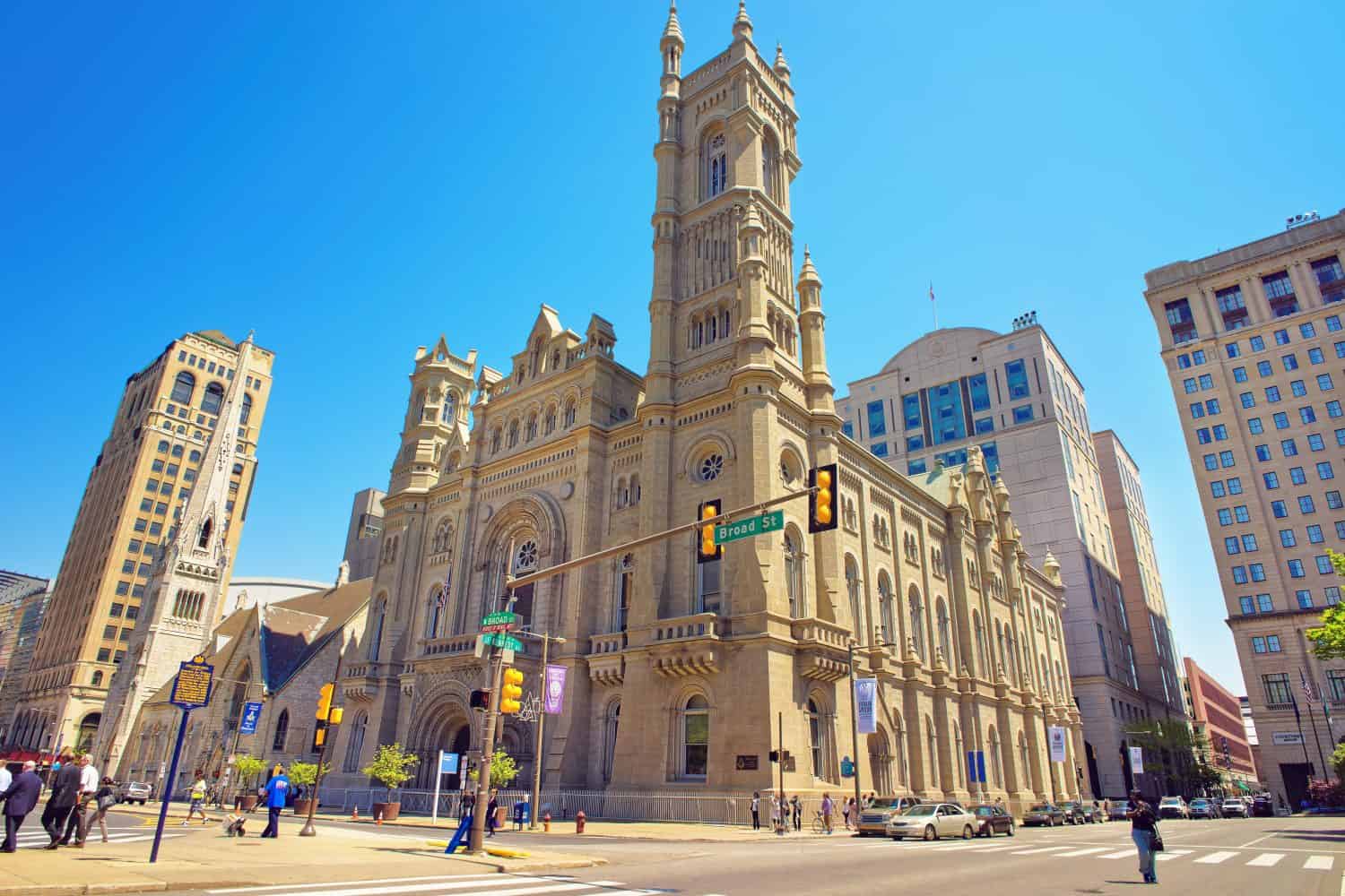 Tempio massonico e grattacieli nella città vecchia di Filadelfia, in Pennsylvania, negli Stati Uniti.  Turisti in strada.  Il Tempio è situato vicino al Municipio