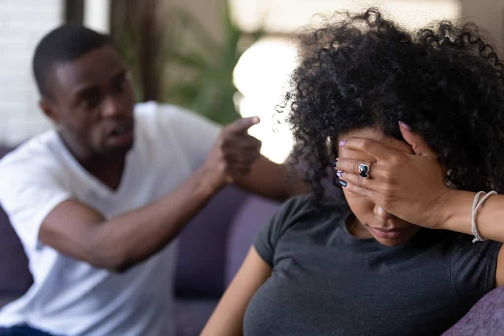 Moglie africana stanca e frustrata che ignora il marito despota nero arrabbiato che discute incolpando la donna sconvolta dei problemi, uomo geloso che grida alla fidanzata triste, litigi familiari e fidanzato controllante, mancanza di rispetto