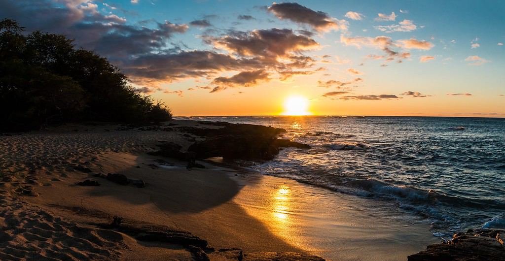 Tramonto sulla sabbia bianca della spiaggia di Kapalaoa sulla baia di Anaeho'omalu, isola di Hawaii, Hawaii, Stati Uniti