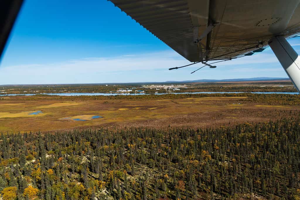 Vista aerea del paesaggio della tundra dell'Alaska, città di King Salmon sullo sfondo, Alaska, USA, ala di aereo