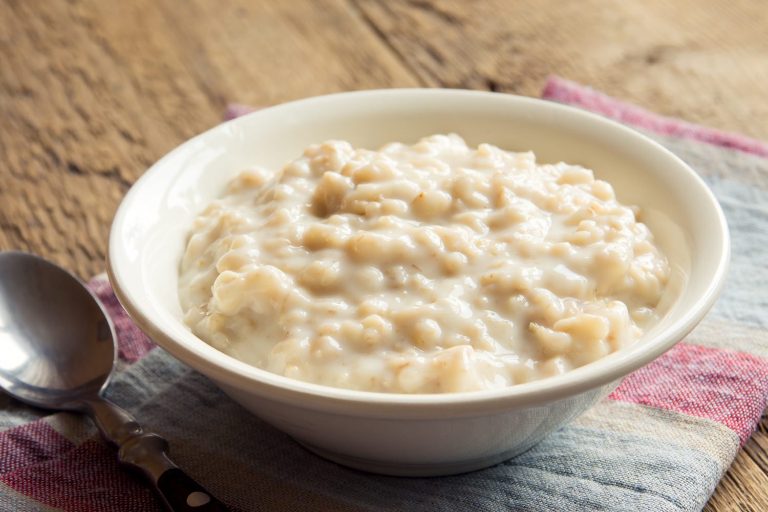Porridge di farina d'avena in una ciotola per la colazione su un tavolo di legno rustico