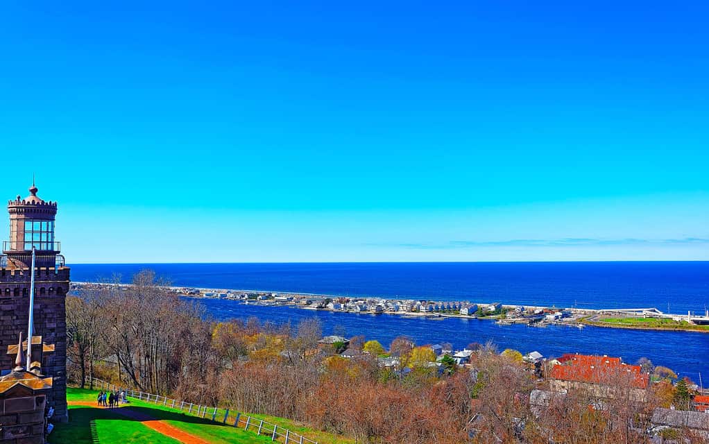 Scenario sulla riva della Baia dell'Oceano Atlantico a Sandy Hook. Vista su New York dal faro o dal faro. Si chiama Navesink Twin Lights. Si trova nelle Highlands nella contea di Monmouth nel New Jersey, negli Stati Uniti. Cielo blu
