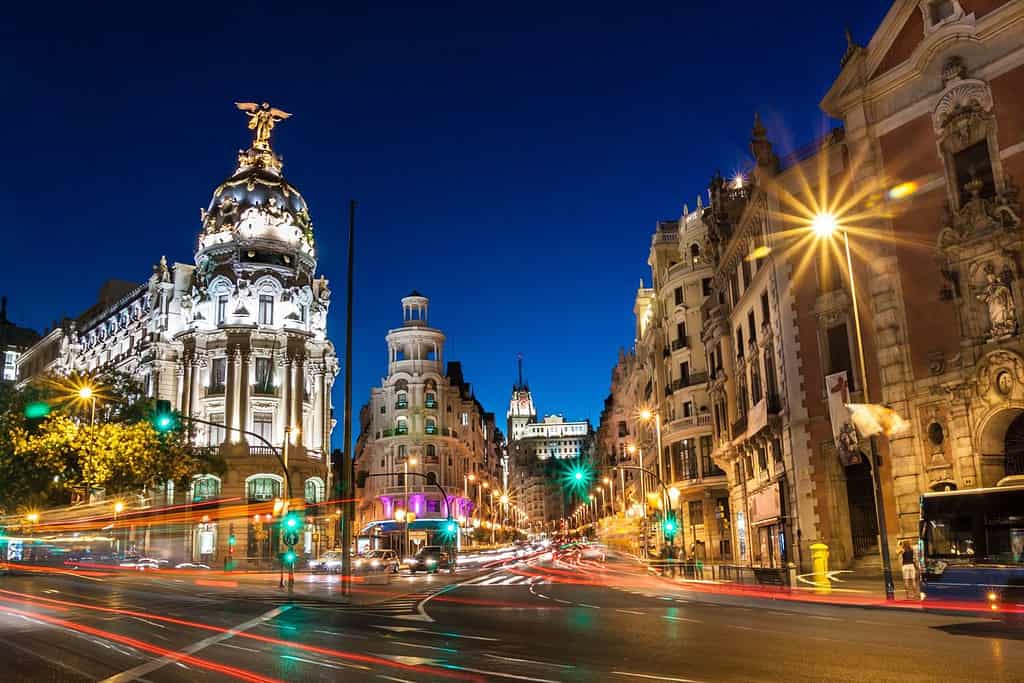 Raggi di semafori sulla Gran Via, la principale via dello shopping di Madrid di notte. Spagna, Europa.