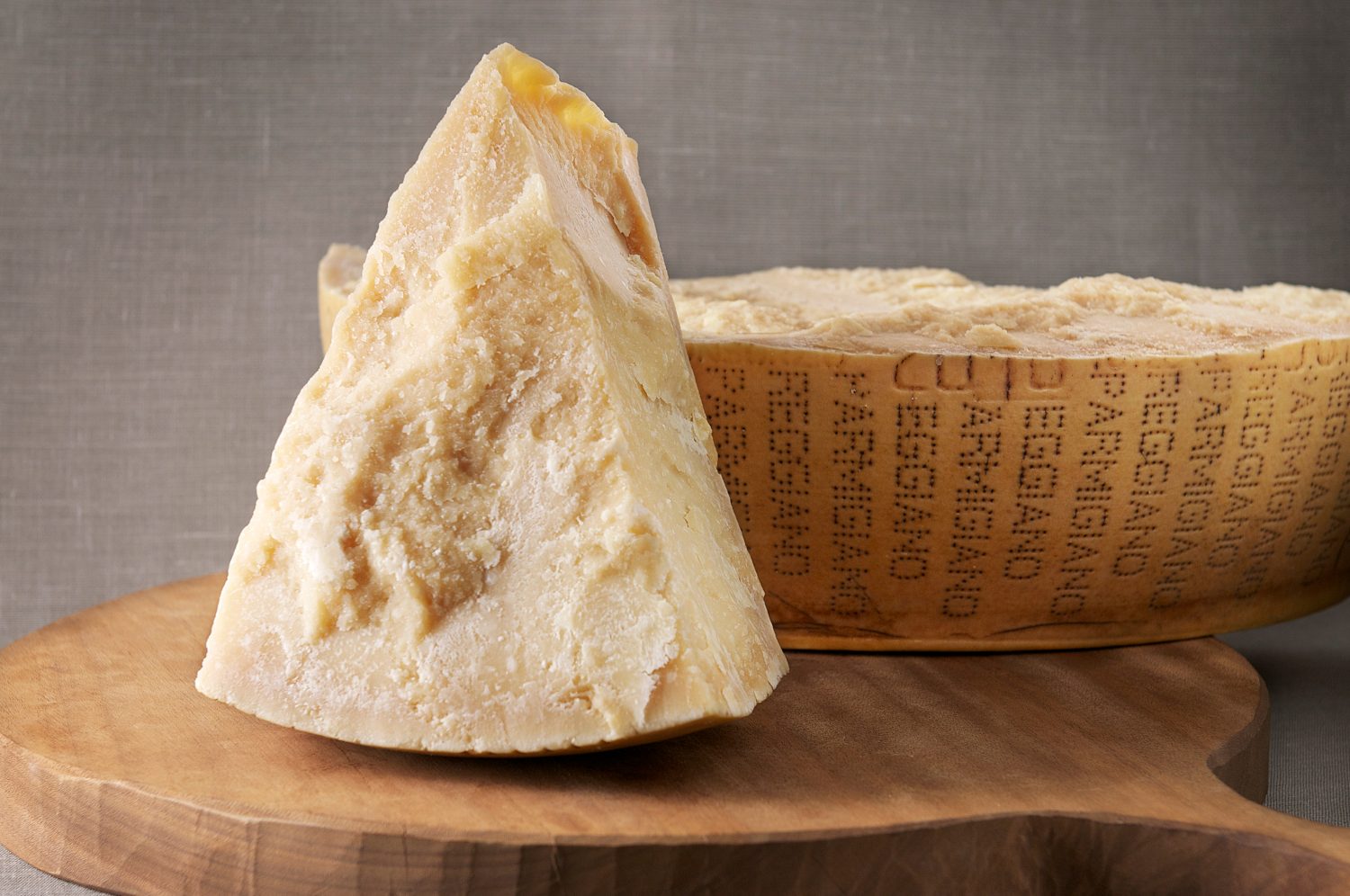 Forma di Parmigiano Reggiano affettata su tagliere di legno