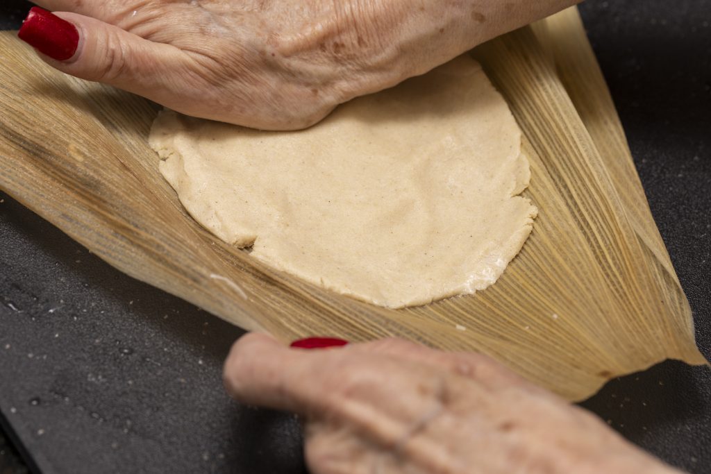 Tamales al peperoncino rosso di manzo assemblati a mano sul ripiano della cucina.