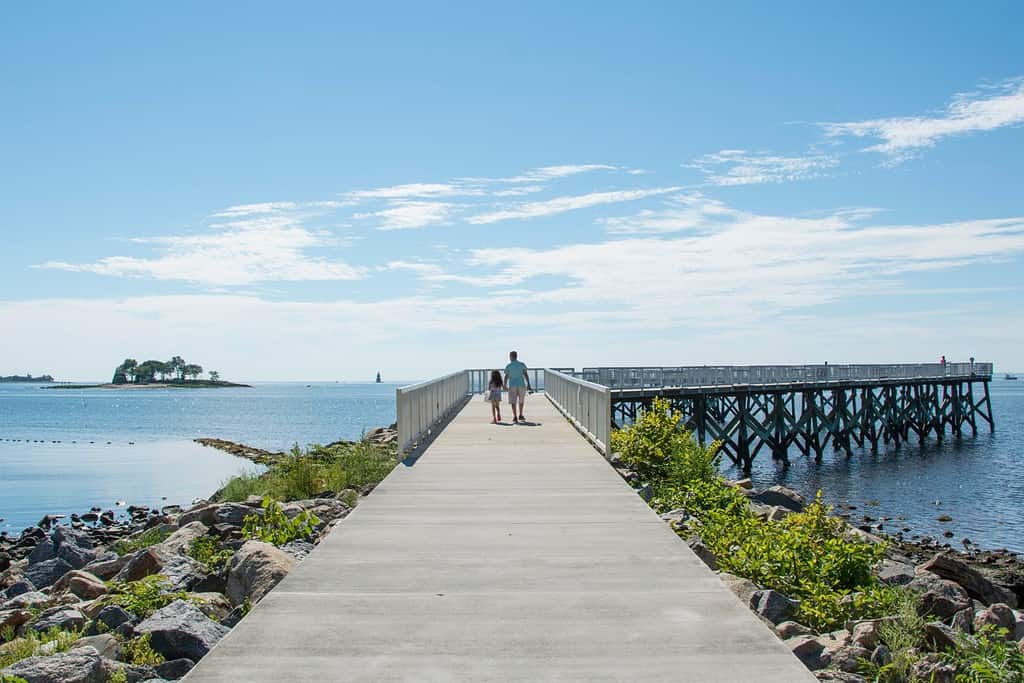 Una vista lungo la passerella del molo in una bella giornata estiva presso il Long Island Sound a Calf Pasture Beach a Norwalk, Connecticut, Stati Uniti