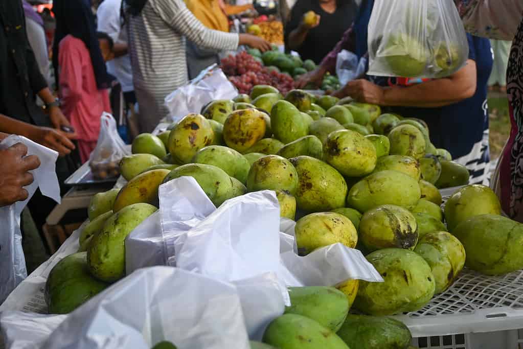 Le persone si affollano per acquistare manghi locali in un mercato tradizionale, in Indonesia.
