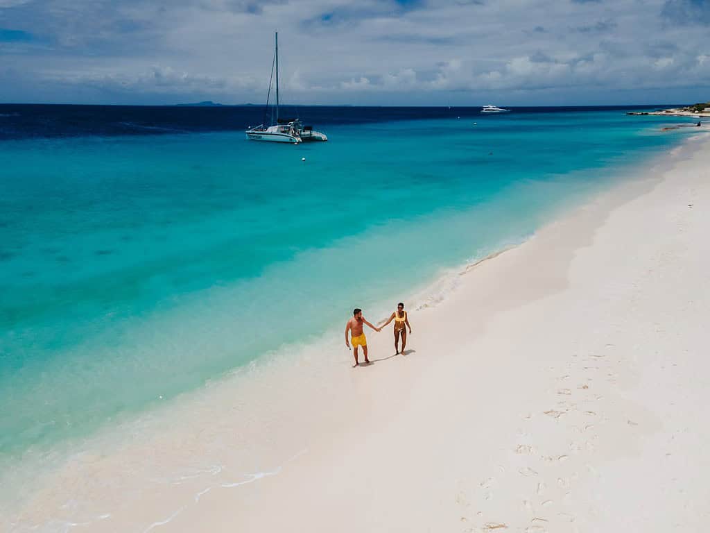 Piccola isola di Curacao famosa per gite di un giorno e tour di snorkeling su spiagge bianche e oceano cristallino, l'isola di Curacao nel Mar dei Caraibi. una coppia di uomini e donne sulla spiaggia durante una vacanza