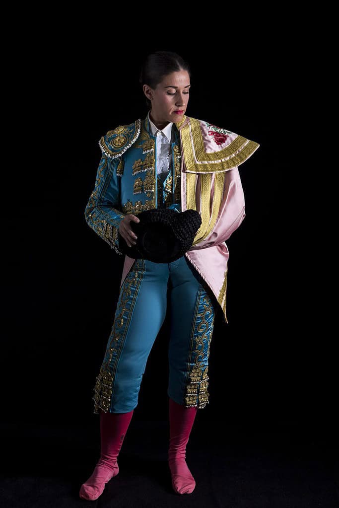 Torero donna con costume blu su sfondo nero