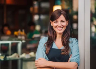 Happy cafe owner stands outside her pest-free business. Learn how to pest-proof your business with these tips from Xceptional Wildlife.